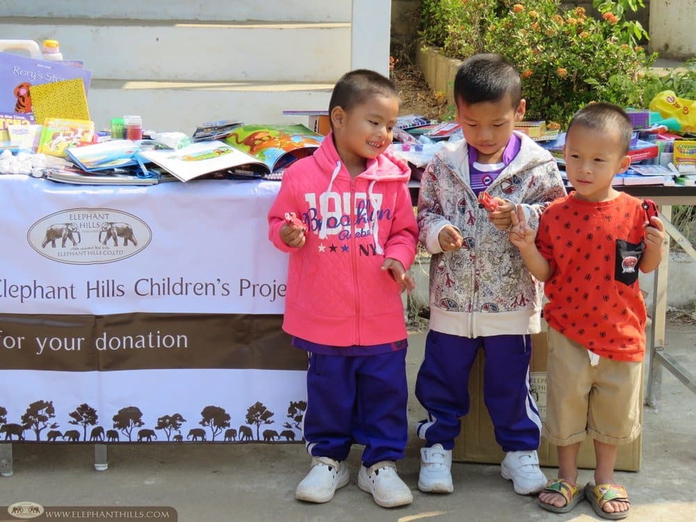 Kids trying out their new clothes and toy cars donated by Elephant Hills' guests