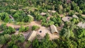 Aerial view of The Bush Camp Chiang Mai's thatched tents with solar panels among the trees